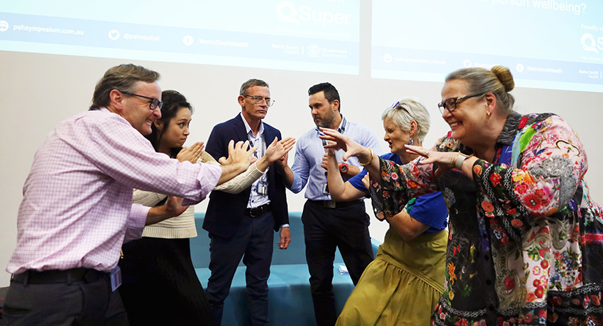 A group of people engaged in a lively discussion or activity at the PAH Health Symposium.