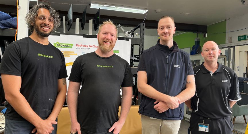 Four environmental hospital service staff standing in front of equipment for recycling