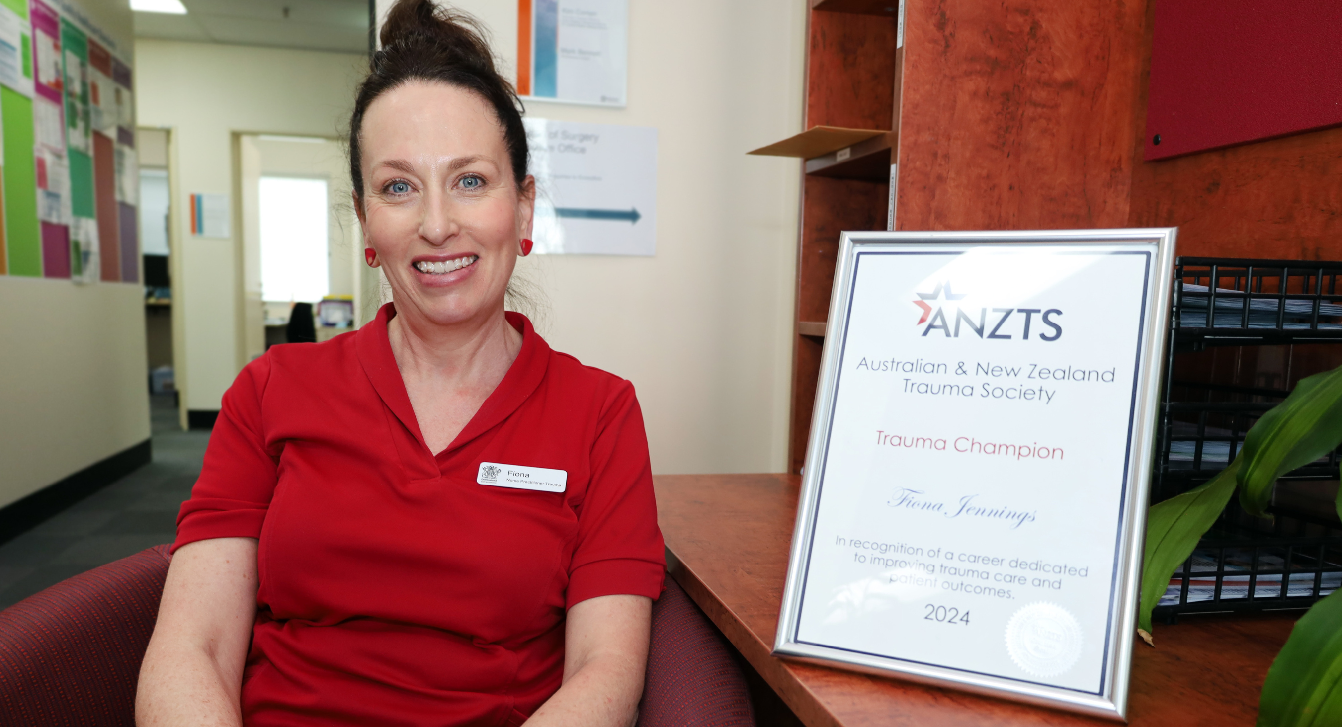 nurse sitting in chair next to award.