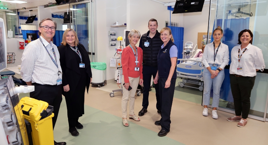 A group of healthcare professionals stands in a hospital room, discussing the newly opened high-dependency dialysis unit at PA Hospital.