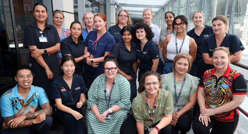 Staff from the Specialist Outpatient Department, featuring people in blue shirts and black pants in a group setting