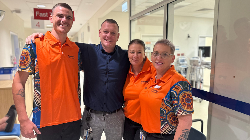 Three healthcare ambassadors stand with their arms over the shoulders of their colleagues. 