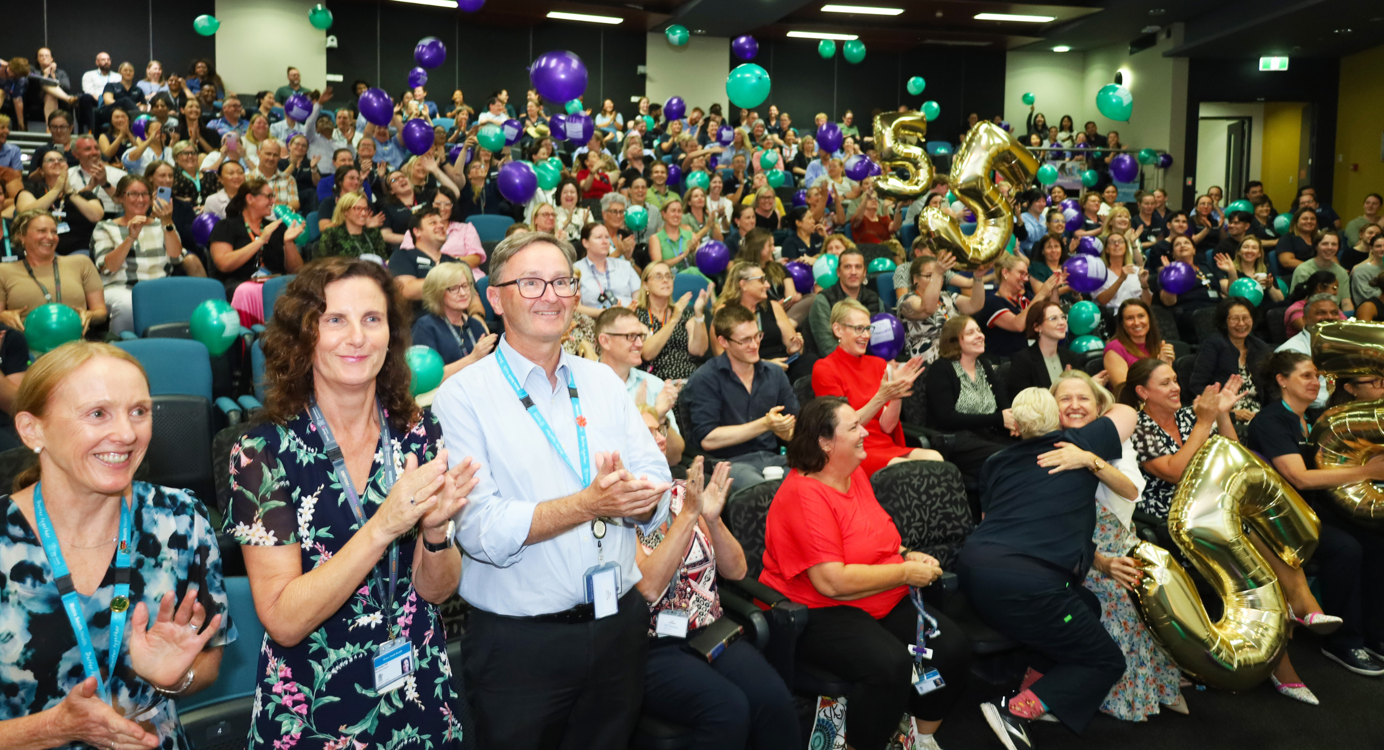 A joyful gathering of PA Hospital staff celebrating the fifth Magnet redesignation, surrounded by colorful balloons